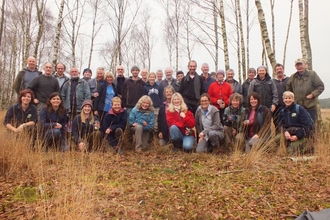 Photo of volunteers grouped together in a wooded area