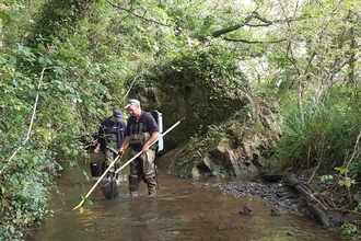 Photo showing two people electro fishing on the Corfe River