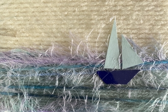 A seascape with a sailing yacht crafted using wool