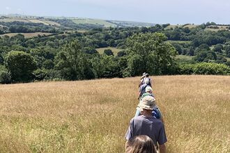 Line of people walking through meadow