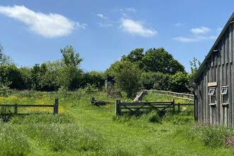 Barn in field with open gate
