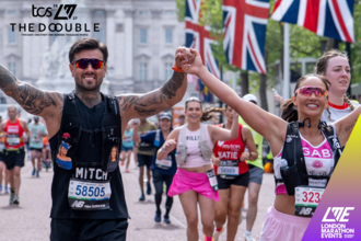 Photo of two people holding hands in the air as they run the London Marathon