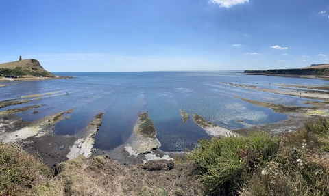 A view of Kimmeridge Bay looking out to sea taken at low tide with rocky ledges exposed