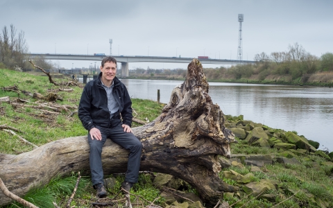 Jeremy sat on a log next to a river