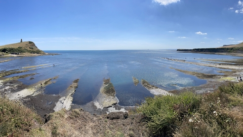 A view of Kimmeridge Bay looking out to sea taken at low tide with rocky ledges exposed