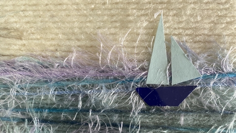 A seascape with a sailing yacht crafted using wool
