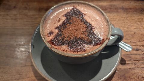 A mug of hot chocolate with a christmas design on top