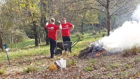 Two volunteers around a bonfire at Lorton Meadows