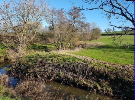 Photo showing river going through countryside 