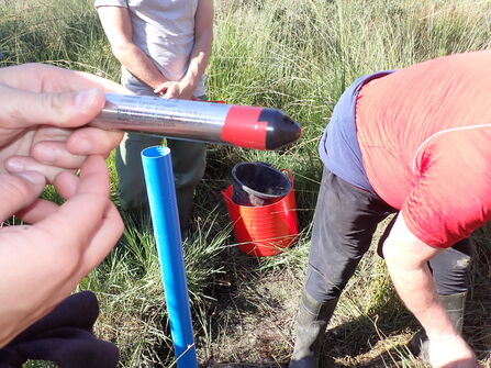 A datalogger with a tube behind buried into the ground 
